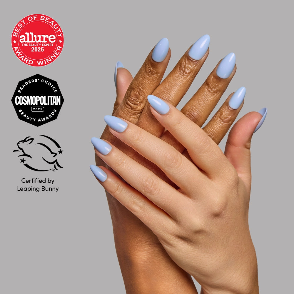 Hands with glossy, short almond Glamnetic Soft Blue press-on nails, accompanied by Allure Best of Beauty, Cosmopolitan Readers Choice, and Leaping Bunny certification award logos.