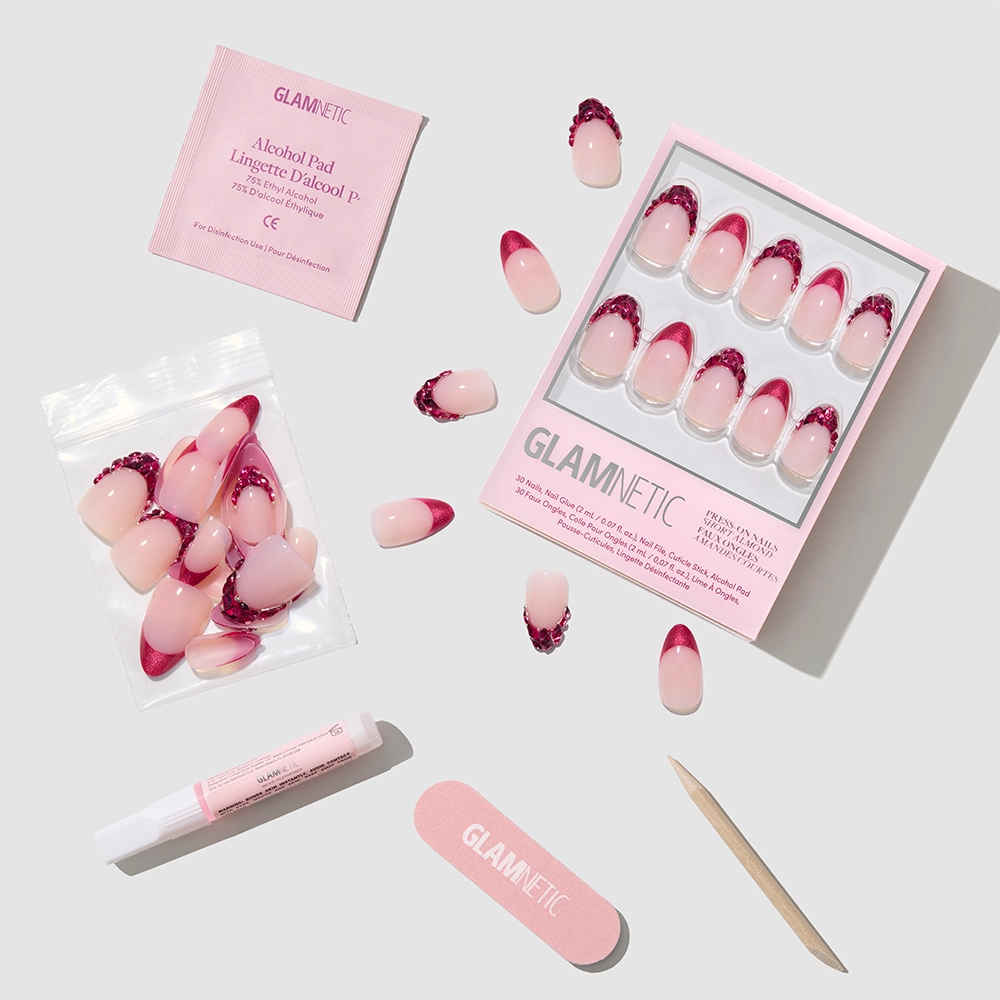 The Spinel Press-On Nails set by glamnetic features pink and magenta glitter nails, pink nude French tips, a nail file, cuticle stick, glue, alcohol pad, and extra nails—organized for salon-quality results. - Product image