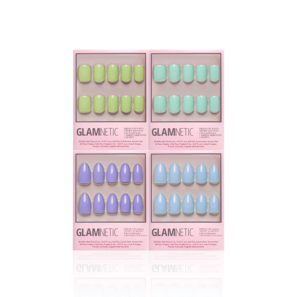 Four pink glamnetic Spring Day press-on nail boxes are shown, each featuring a different pastel shade—green, blue, lilac, and light blue—with nails arranged in two rows against a white background.