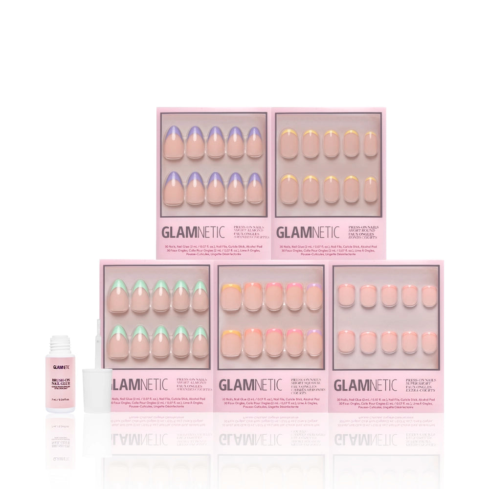 Six boxes of glamnetic’s Spring French Tip Collection press-on nails in pastel and French tip designs are arranged in two rows with a nail glue bottle to the left, all set against a white background. - Product image
