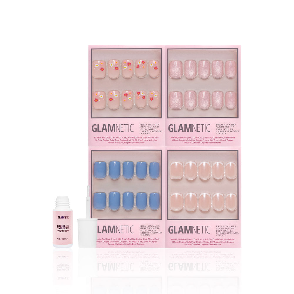 Four sets of glamnetic Springtime Squovals press-on nails in pink packaging feature floral, glittery pink, solid blue, and nude pink designs. An open nail glue bottle is in front—perfect for fresh spring nails at home. - Product image