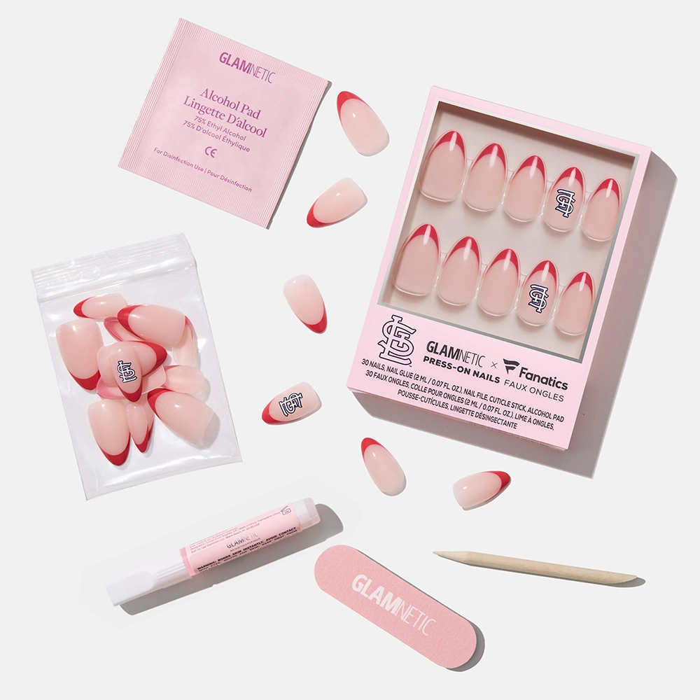 The glamnetic St. Louis Cardinals Press-On Nail Set features pink nails with red tips and a sports logo, plus an alcohol pad, nail glue, cuticle stick, nail file, and extra nails, all displayed on a white background. - Product image