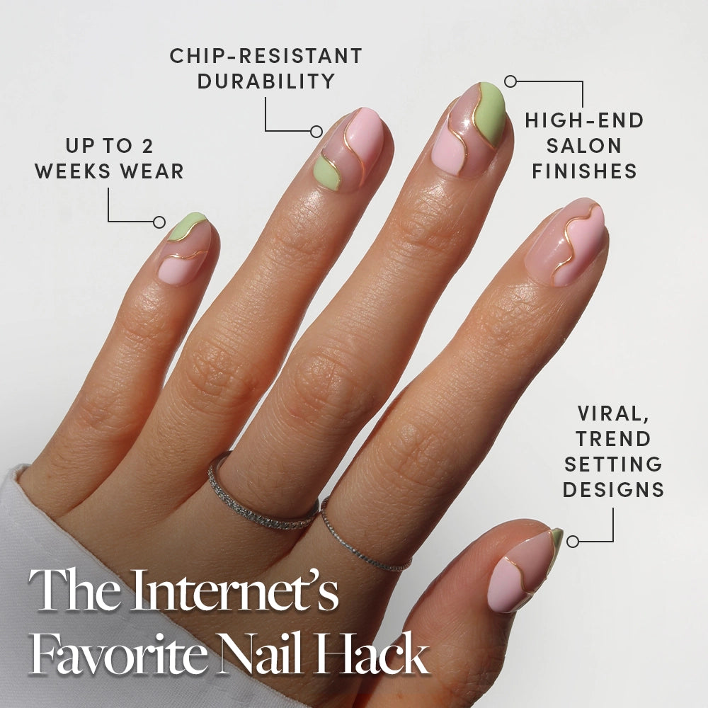 A hand shows off glamnetic's Strawberry Matcha press-on nails—pink and light green with gold lines—for café-cute, trend-setting style. Durable, chip-resistant, luxe finish lasts up to 2 weeks. Two fingers sport rings. - Product image