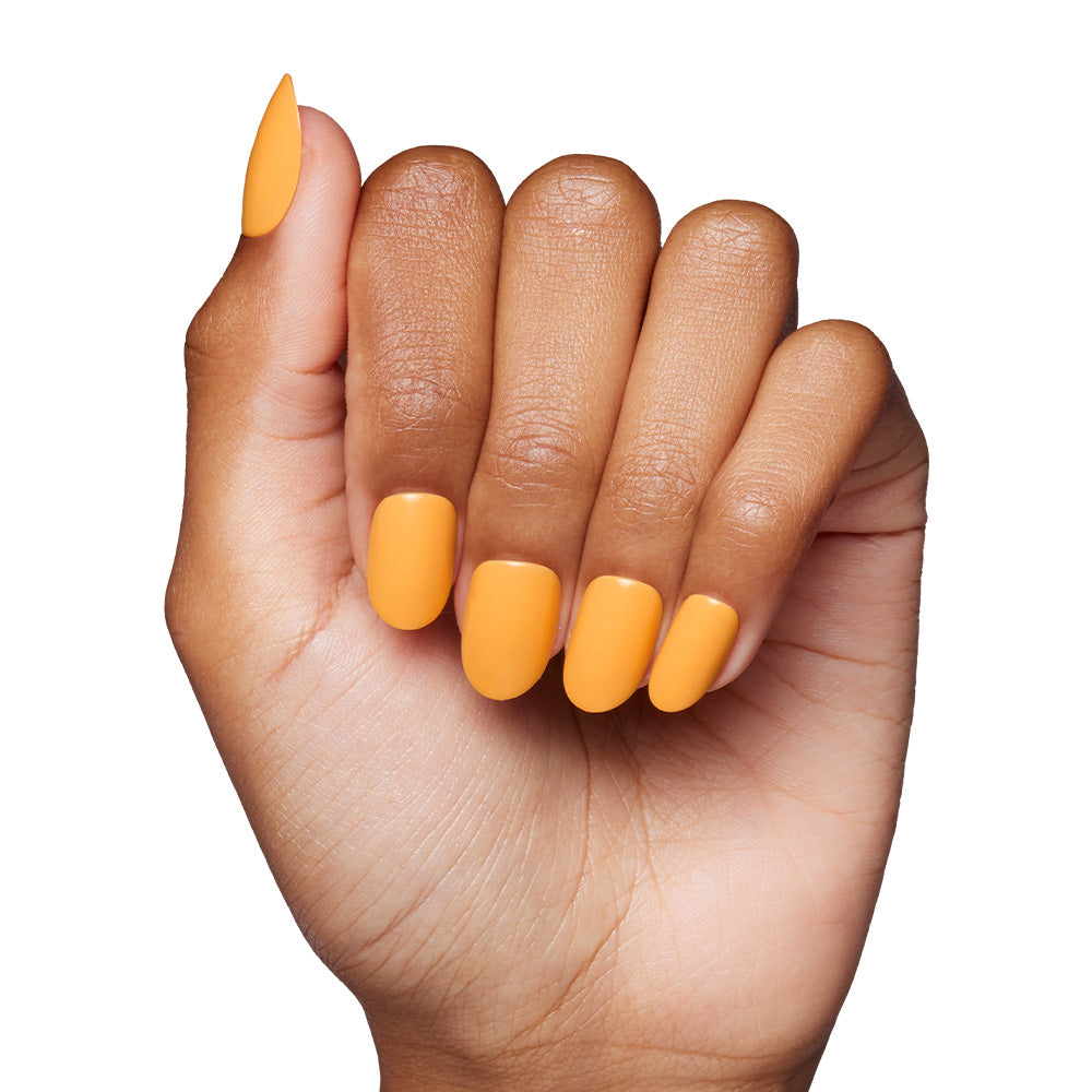 A hand with medium brown skin and neatly manicured nails painted in glamnetic’s Sunset Orange, a bold shade perfect for summer, is shown against a clean white background. - Product image