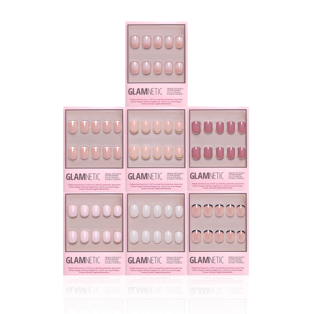 Six boxes of glamnetic Super Short Icons press-on nails in various pink and nude shades, including milky and French tip styles, are arranged pyramid-style on a white background. Each box shows a unique nail color and style through a clear window. - Product image