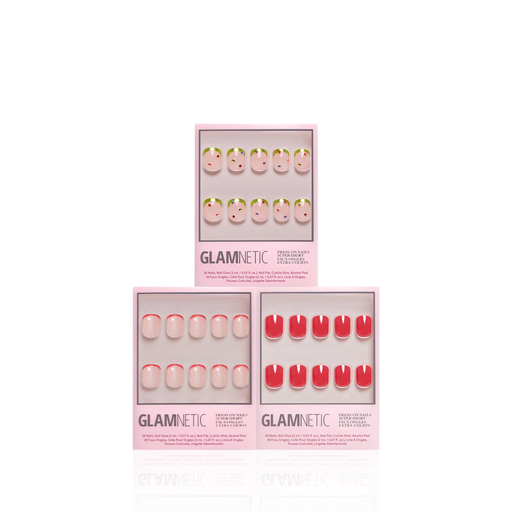 Three boxes of glamnetic Super Short Stop press-on nails are arranged in a triangle. The designs include pink with green tips, solid pink, and solid red. Each box features multiple natural-looking press-on nails displayed in a clear window, offering salon-quality press-on manis for any occasion. - Product image