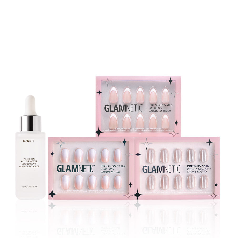 A bottle of glamnetic cuticle oil with a dropper sits beside three boxes of glamnetic Sweater Weather press-on nails in light pink, displayed in pink packaging with a clear window and Nail Glue included. - Product image