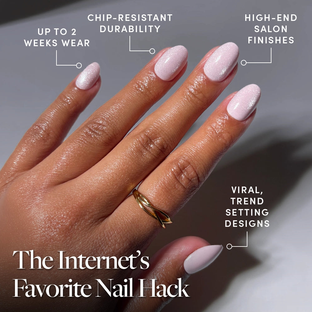 A hand with Sweet Talk by glamnetic—glossy pink shimmer press-on nails in a short oval shape—is shown. Benefits include up to 2 weeks wear, chip-resistant durability, salon-quality finish, and viral trend-setting design. A gold ring accents one finger. - Product image
