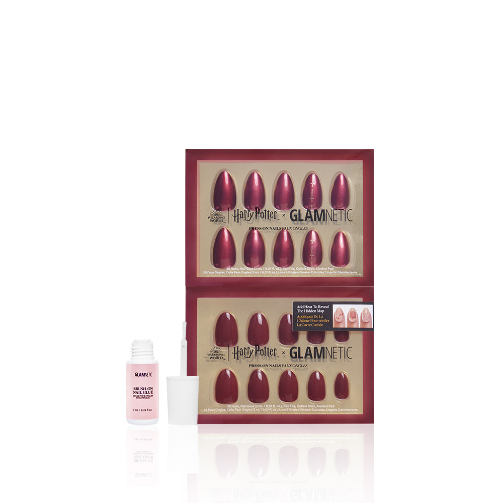 Two sets of Team Gryffindor™ press-on maroon nails by glamnetic are stacked in Harry Potter x glamnetic packaging. In front sits an open bottle of vegan, cruelty-free pink nail glue with a brush applicator, all on a white background. - Product image