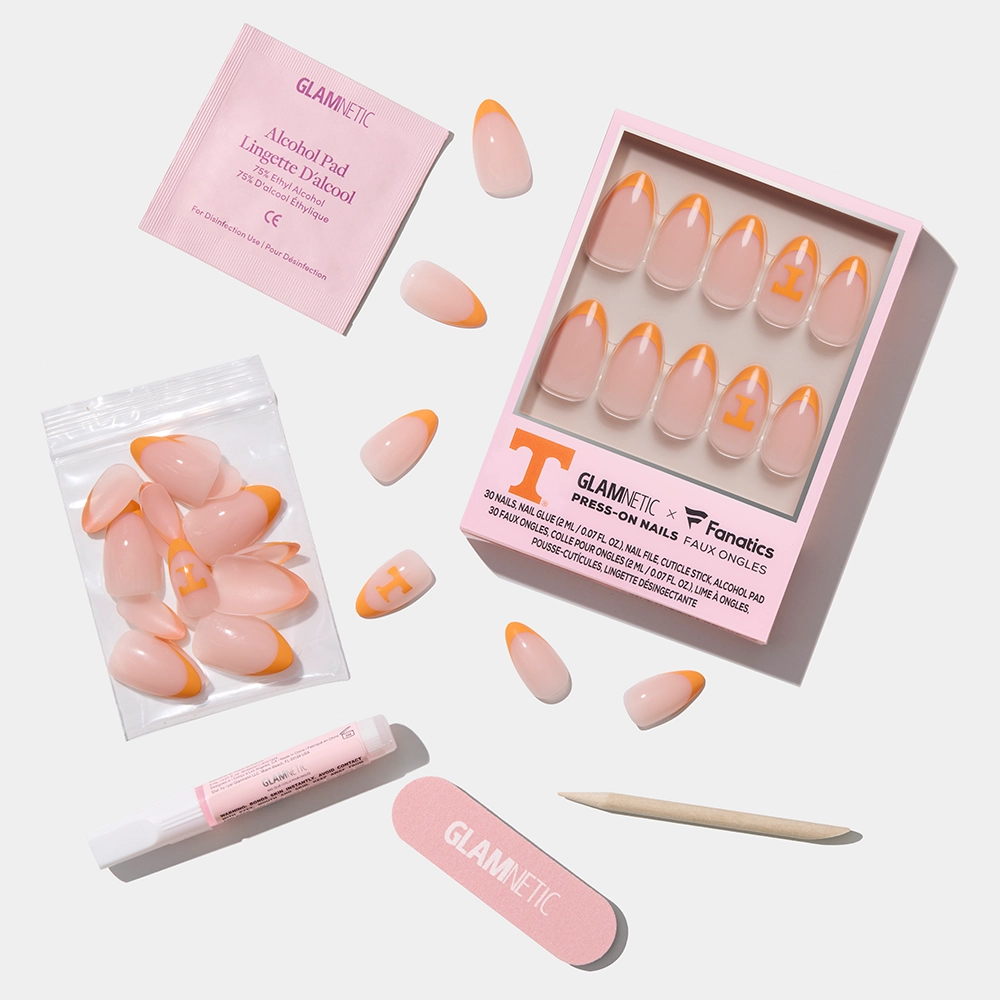 The glamnetic Tennessee Volunteers Press-On Nail Set features orange French tips and a white T accent, and comes with a nail file, cuticle stick, glue, alcohol pad, and extra nails—all displayed on a white background. - Product image