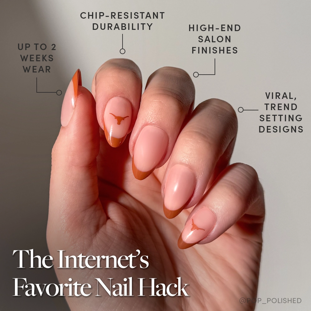 A hand with almond-shaped nails—pink base, brown French tips, and minimalist brown art—wears the glamnetic Texas Longhorns Press-On Nail Set. Durable with salon finishes and viral design. Text: The Internet’s Favorite Nail Hack. - Product image