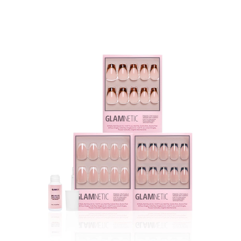 Three pink glamnetic boxes of The Medium Coffin Frenchies nails are stacked, each displaying a nude and white French tip set in medium coffin shape. An open nail glue bottle sits to the left on a clean white background. - Product image