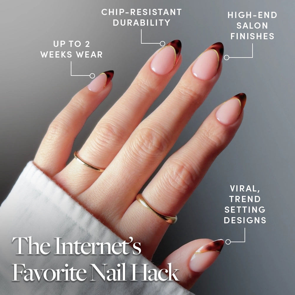 A hand with almond-shaped glamnetic "The Original" press-on nails in a dark gradient French tip. Text highlights chip-resistant durability, up to 2 weeks’ wear, luxe finishes, and viral trendy style. The hand wears two gold rings. - Product image