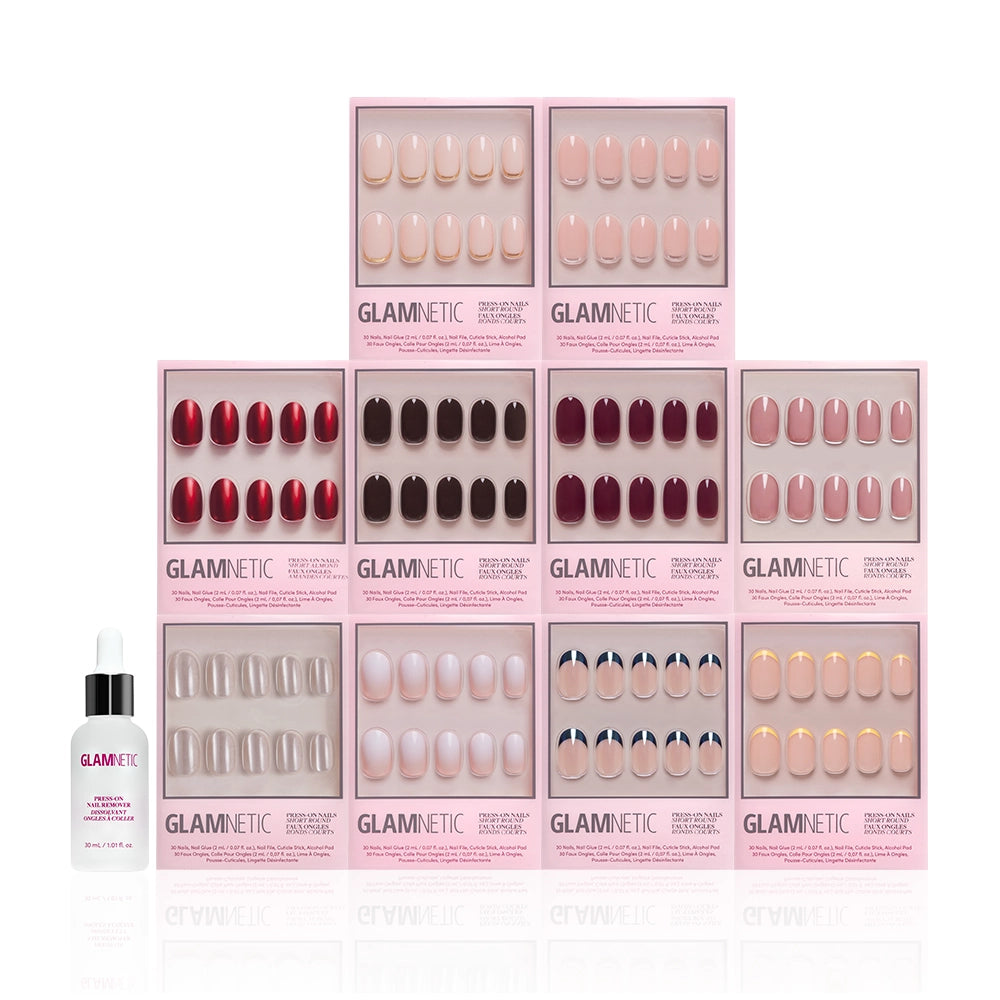 A display of ten glamnetic The Round Vault press-on nail kits, arranged in a pyramid shape, features short round and limited-edition options, with a bottle of glamnetic nail glue at the bottom left. - Product image