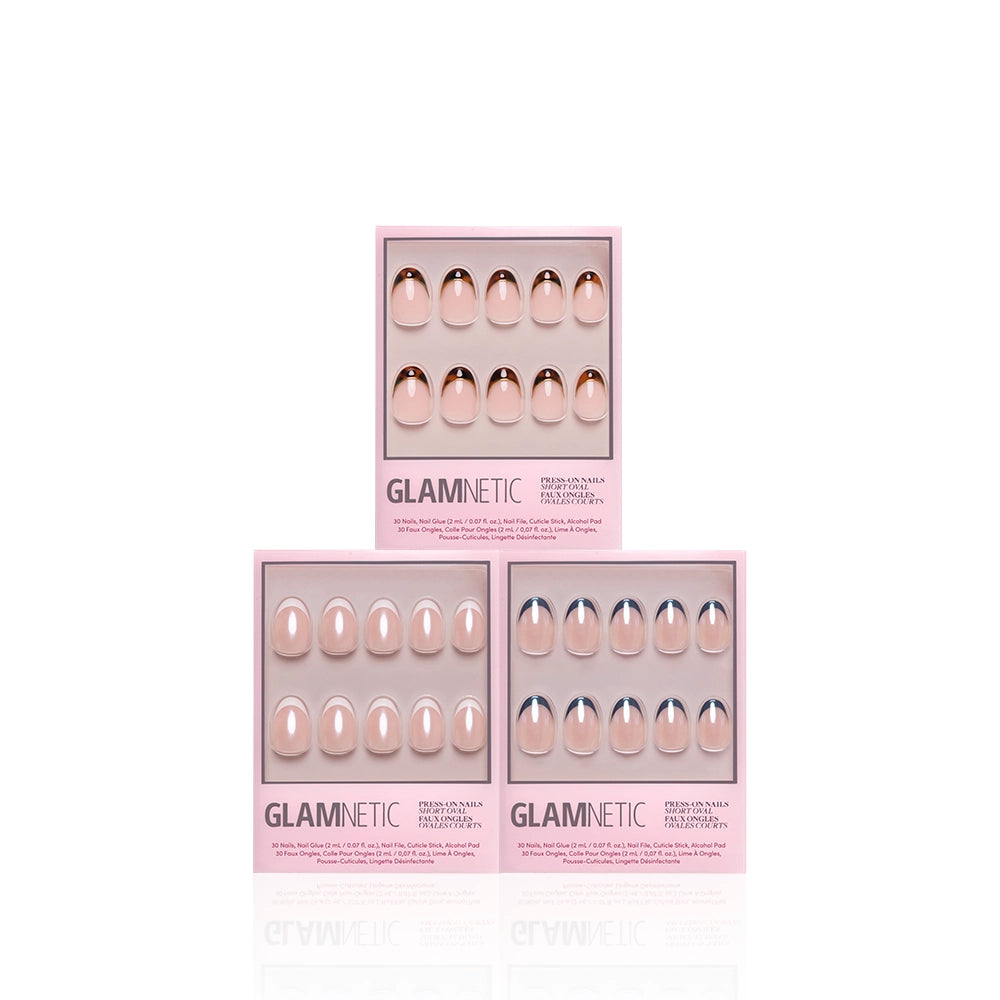 Three pink glamnetic boxes of The Short Oval Frenchies press-on nails are arranged in a pyramid on a white background, each showing nude, almond-shaped French tip nails through a clear window. - Product image