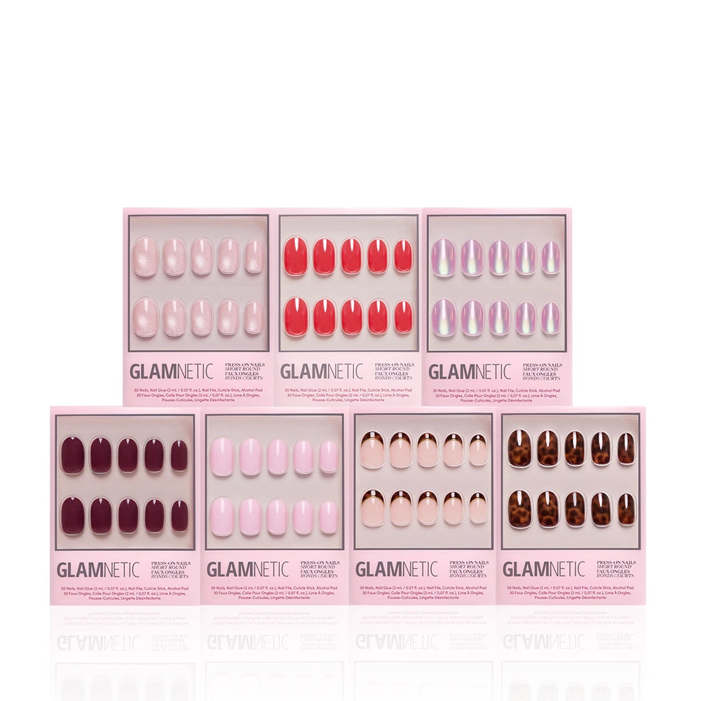 Seven boxes of glamnetic’s The Short Round Edit press-on nails, featuring pink, red, purple, nude, and tortoiseshell shades, are arranged in two rows on a white background—perfect for creating your ideal mani wardrobe. - Product image