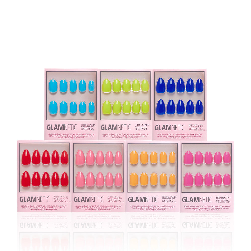 A display of seven Glamnetic Summer Vivids Collection press-on nail boxes in vibrant blue, green, red, pink, yellow, and orange shades, arranged in two rows against a white background. - Product image