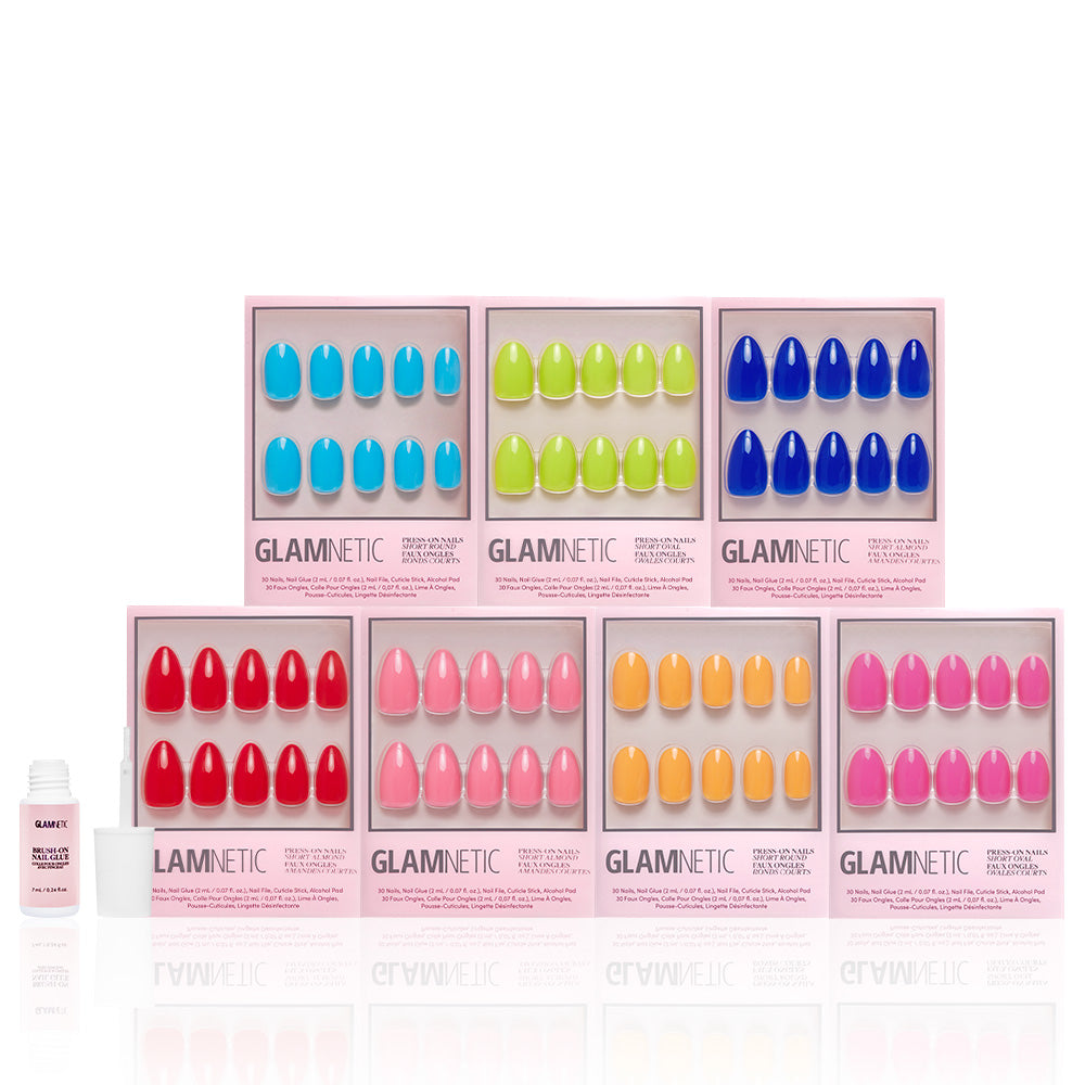 Seven boxes of glamnetic’s Summer Vivids Collection press-on nails in vibrant blue, green, navy, red, pink, orange, and yellow are arranged in two rows with a small nail glue bottle placed in front. - Product image