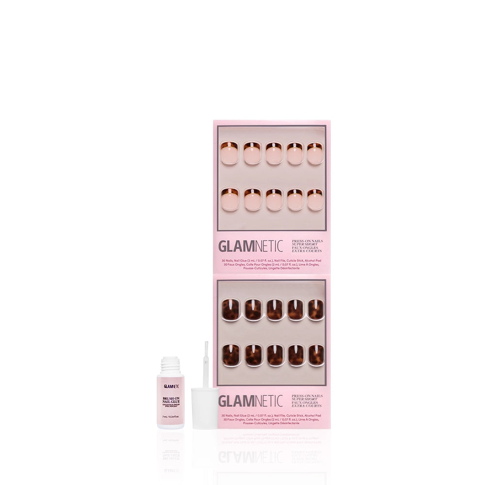 A set of glamnetic The Super Short Tortoiseshell Duo press-on nails in two pink boxes is displayed upright, with a small open bottle of pink nail glue and brush applicator placed in front on a clean, white background. - Product image
