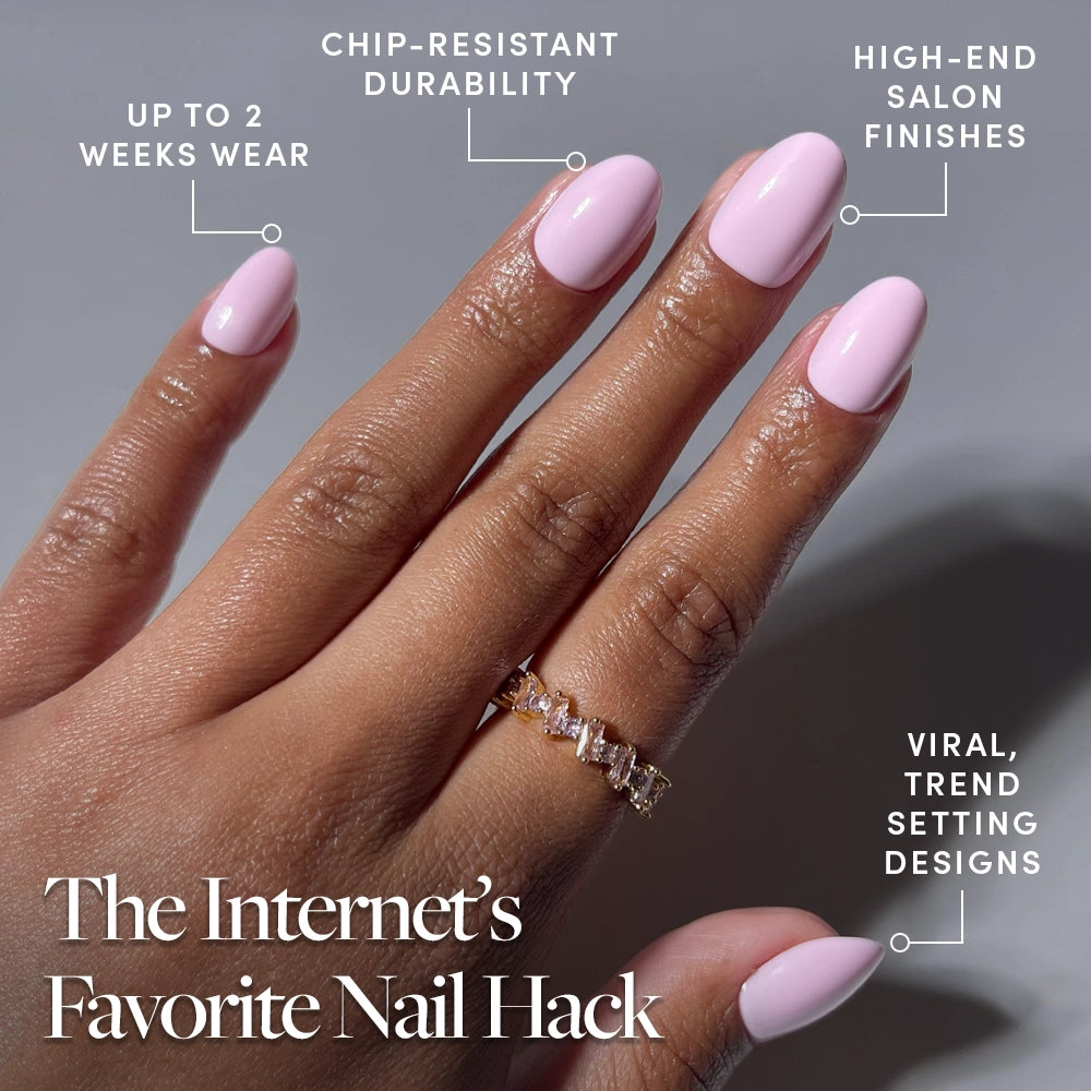 A hand with glamnetic’s Think Pink short oval press-ons in baby pink is shown, featuring a gold ring. Text notes up to 2 weeks wear, chip-resistant durability, salon-quality finish, and viral trendy designs. - Product image