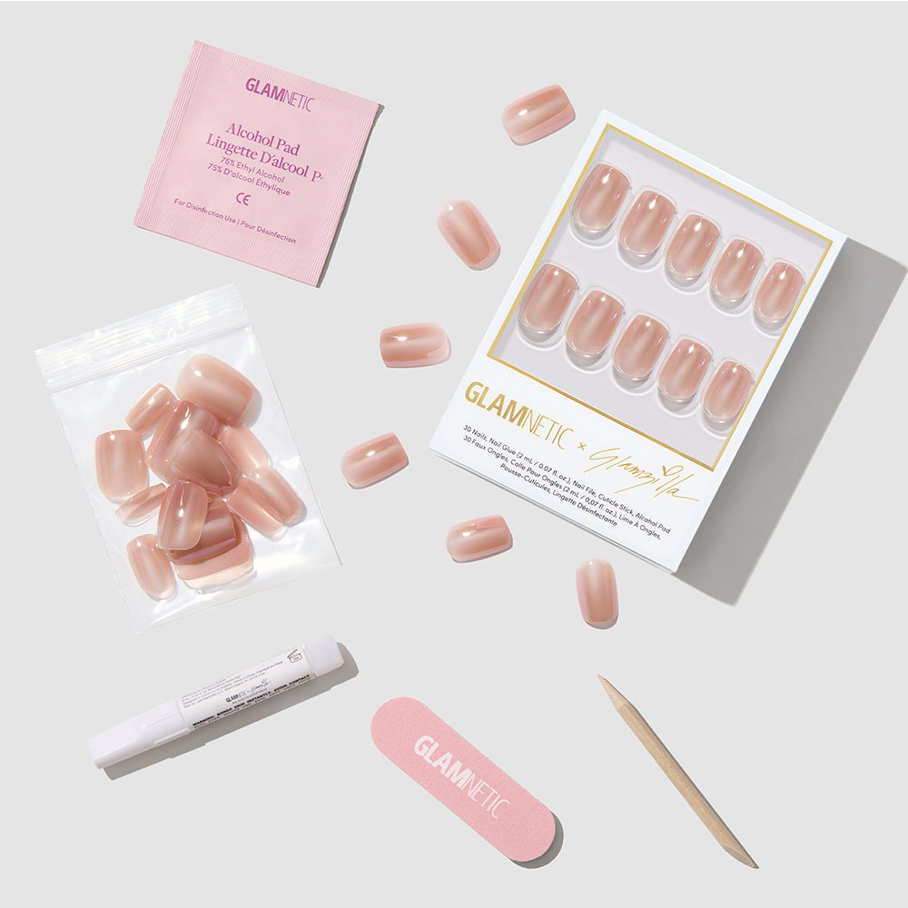 The glamnetic THRILLA IN MANILA set includes pink short squoval press-on nails, adhesive, extra nails, an alcohol pad, a nail file, and a wooden cuticle stick—everything for the perfect nude manicure displayed on a white surface. - Product image