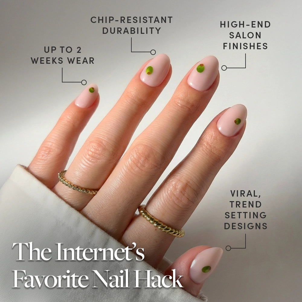A hand with short oval nails in glamnetic’s Tipsy Olive design—nude base and green dots—wears gold rings. Informational text highlights the press-on nail’s chip-resistant durability, two-week wear, salon finish, and trendy style. - Product image