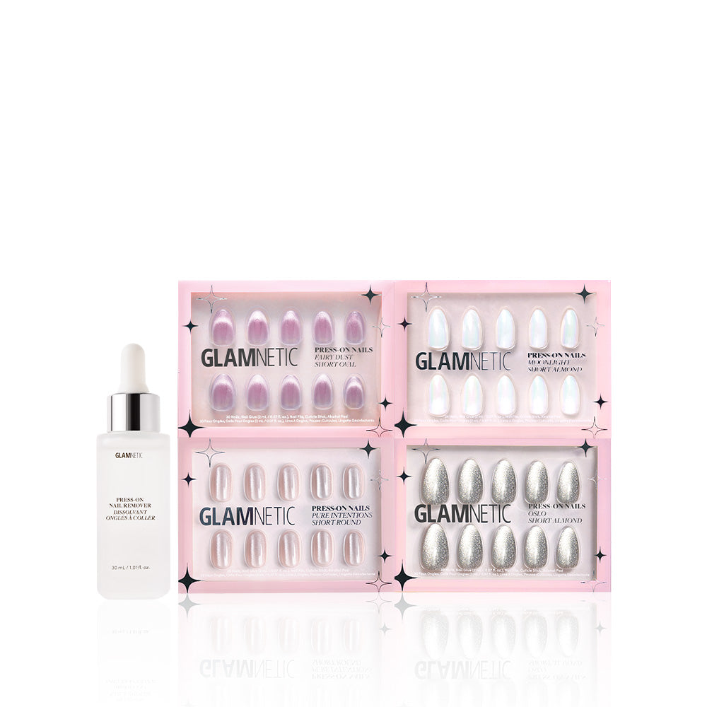 The glamnetic To the Stars press-on nails set in four pink and silver styles is displayed in pink boxes next to a white nail glue dropper bottle, all arranged on a white background. - Product image