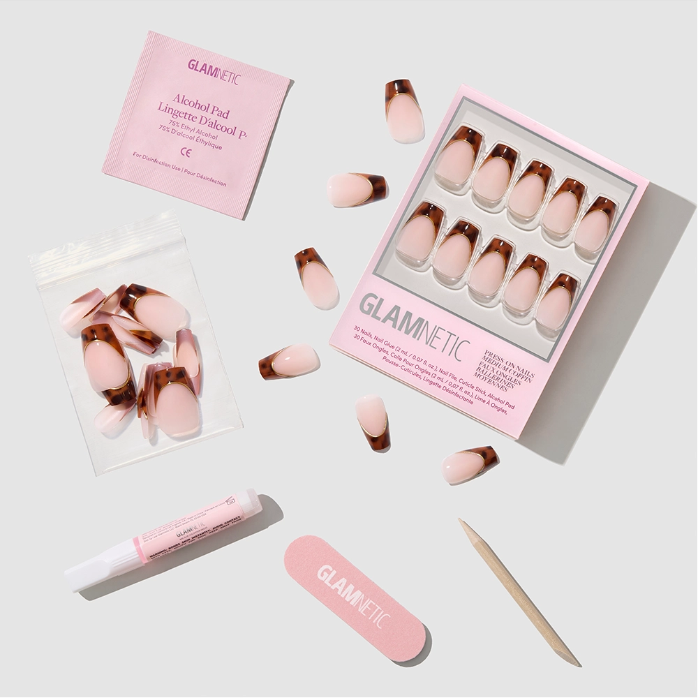 The Top Tier press-on nails set by glamnetic includes pink gradient coffin-shaped nails, nail glue tube, wooden cuticle stick, emery board, alcohol pad, and extra nails—all displayed on a white background. - Product image