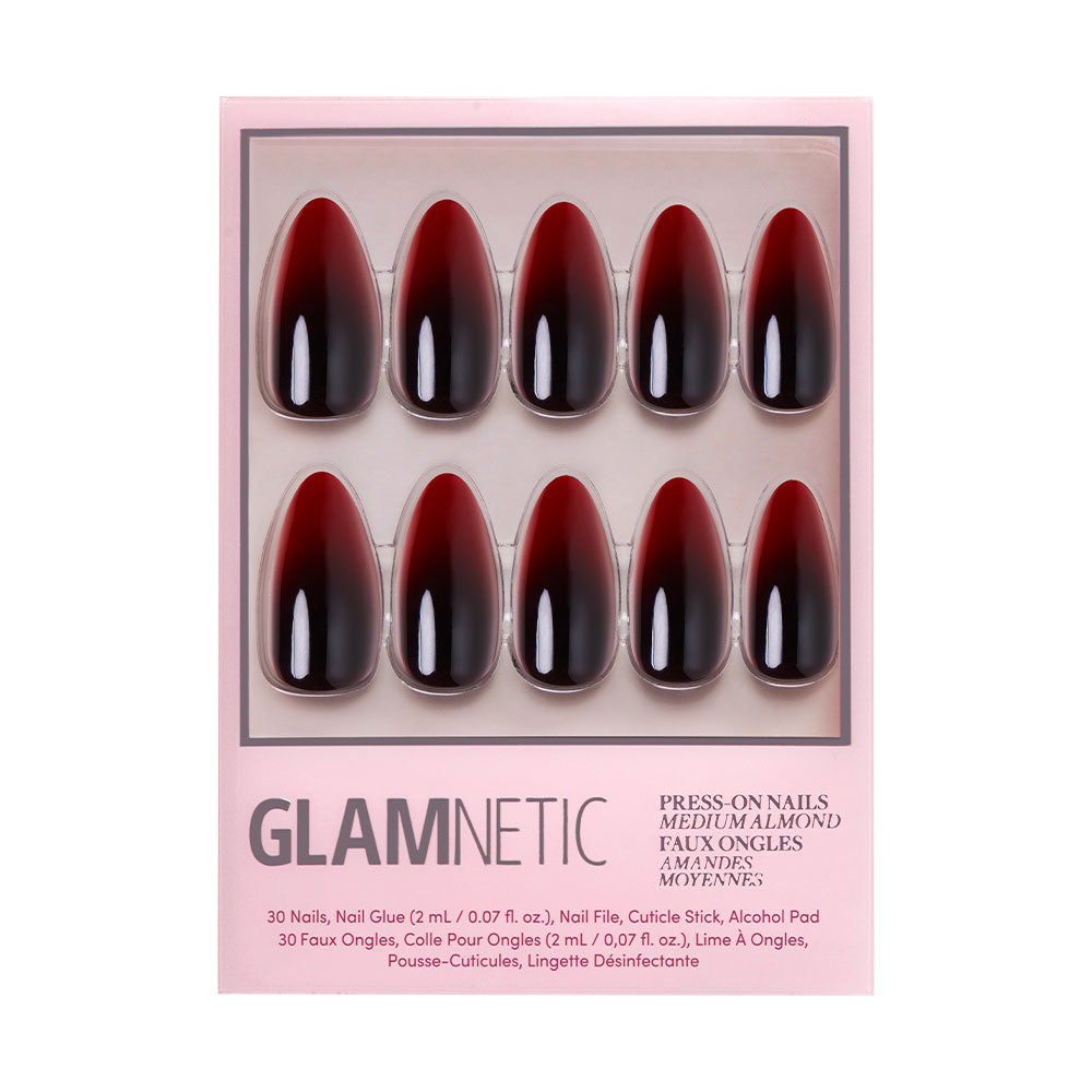 A box of glamnetic Vampiress press-on nails, showcasing bold black-to-blood ombre tips arranged in two rows of five against a pink backdrop. The set comes complete with nail glue, a nail file, and a cuticle stick—ideal for creating glamorous Halloween nails.