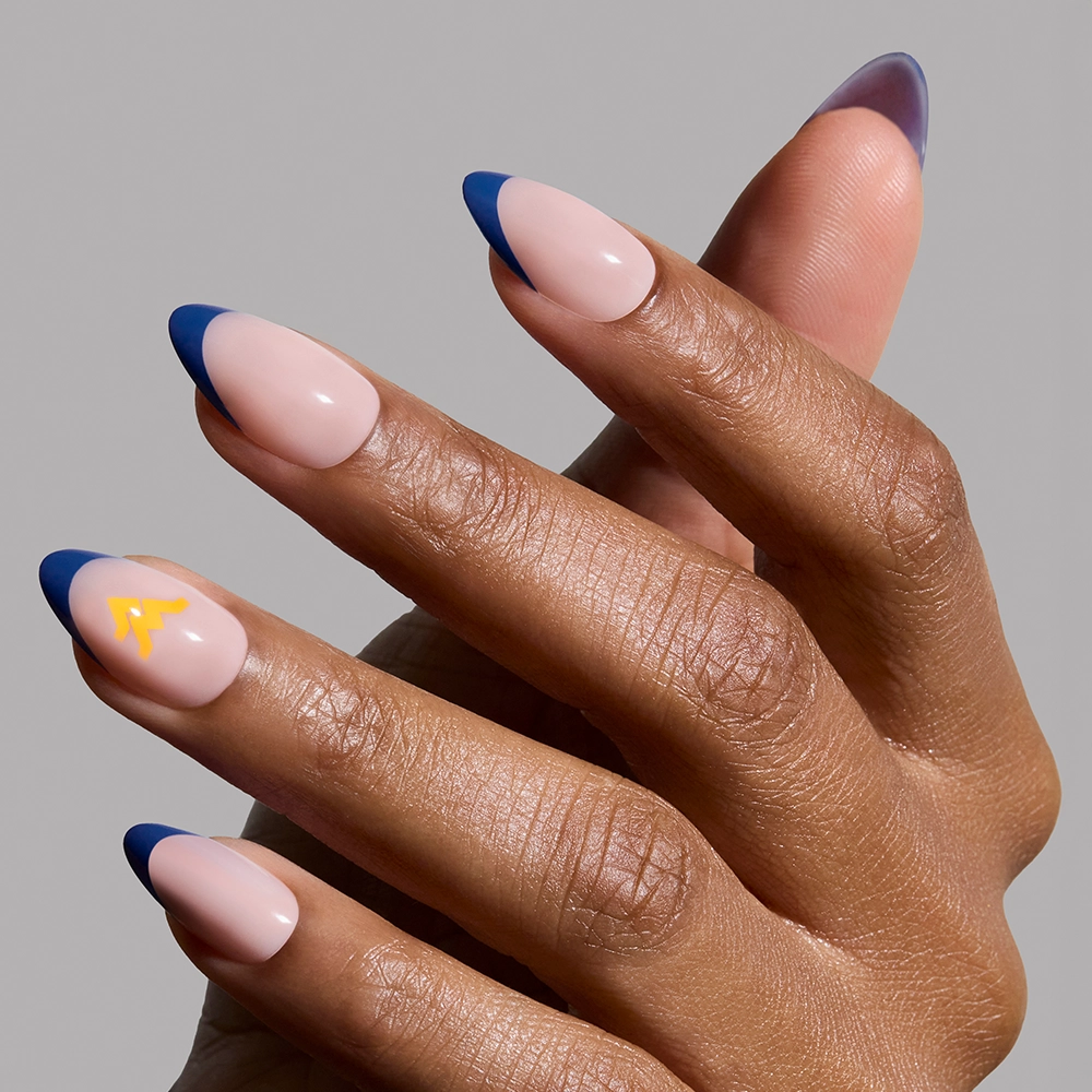 The glamnetic West Virginia Mountaineers Press-On Nail Set features almond-shaped nails with a nude base, dark blue French tips, and a yellow abstract accent—perfect for game day. Shown on a plain light gray background. - Product image