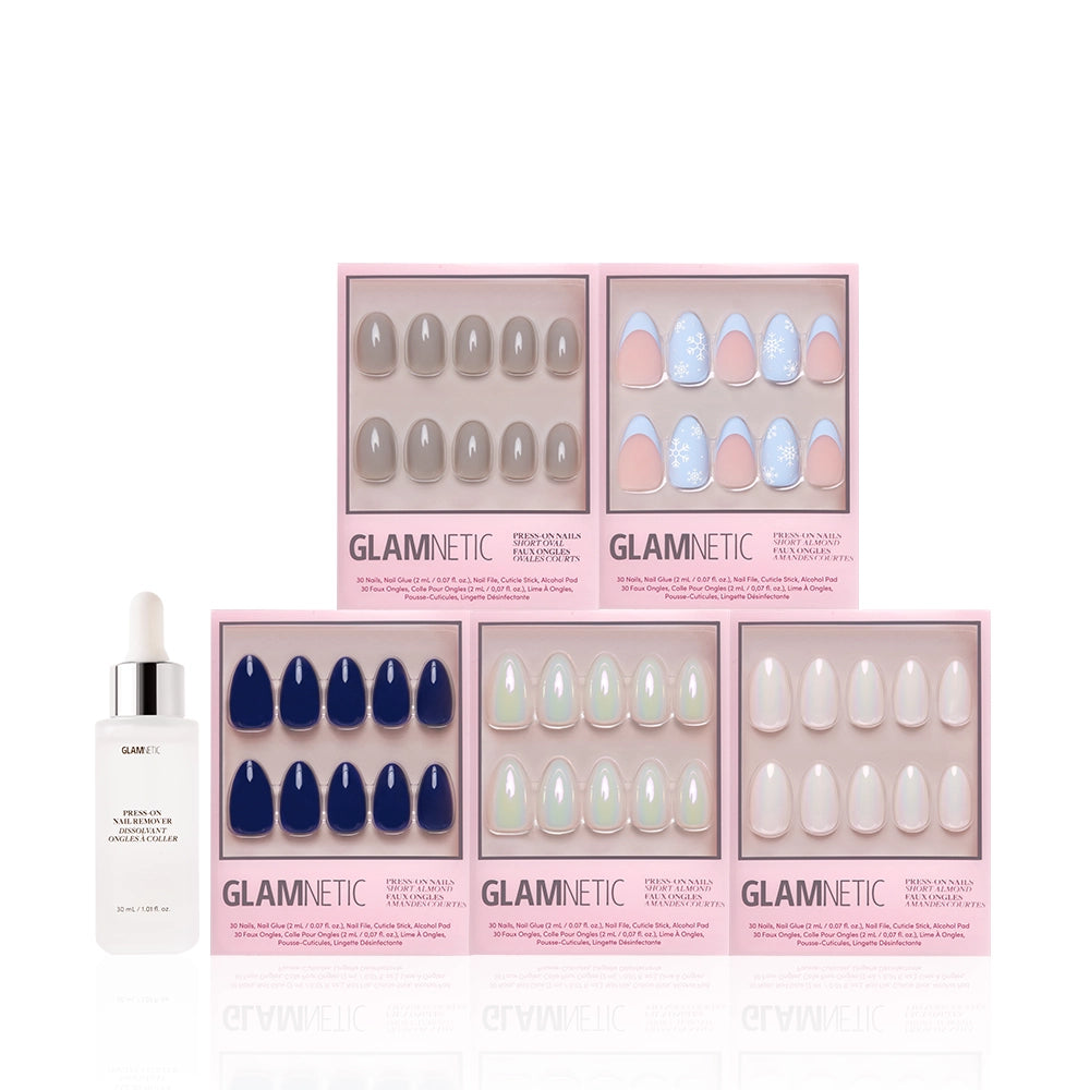 Five sets of artificial nails from the glamnetic Winter Toast Bundle are displayed in pink glamnetic packaging above a bottle of glamnetic cuticle oil with a dropper, all arranged on a white background. - Product image