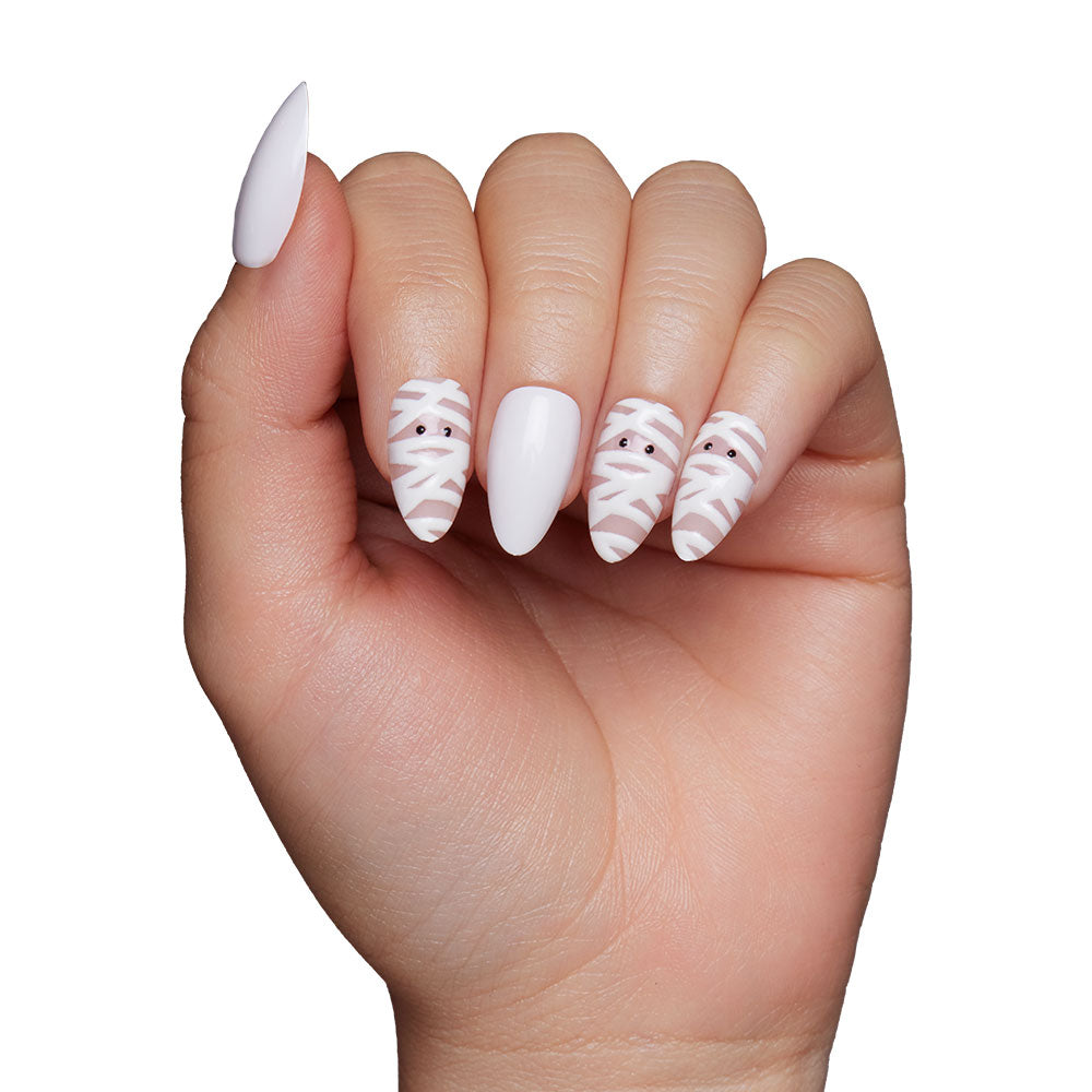 Glamnetic’s Wrapped Up features a short almond design with three mummy face nails wrapped in white and black eyes, plus two solid white nails for a fun, playful look. - Product image