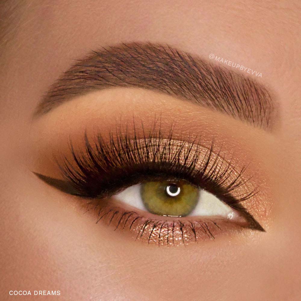 Close-up of a green iris eye with bold black winged eyeliner applied using the glamnetic Magnetic Eyeliner Pen Duo, long dramatic lashes, shimmering gold and brown eyeshadow, and a thick, defined brow. Highly pigmented shades. Text reads COCOA DREAMS. - Product image